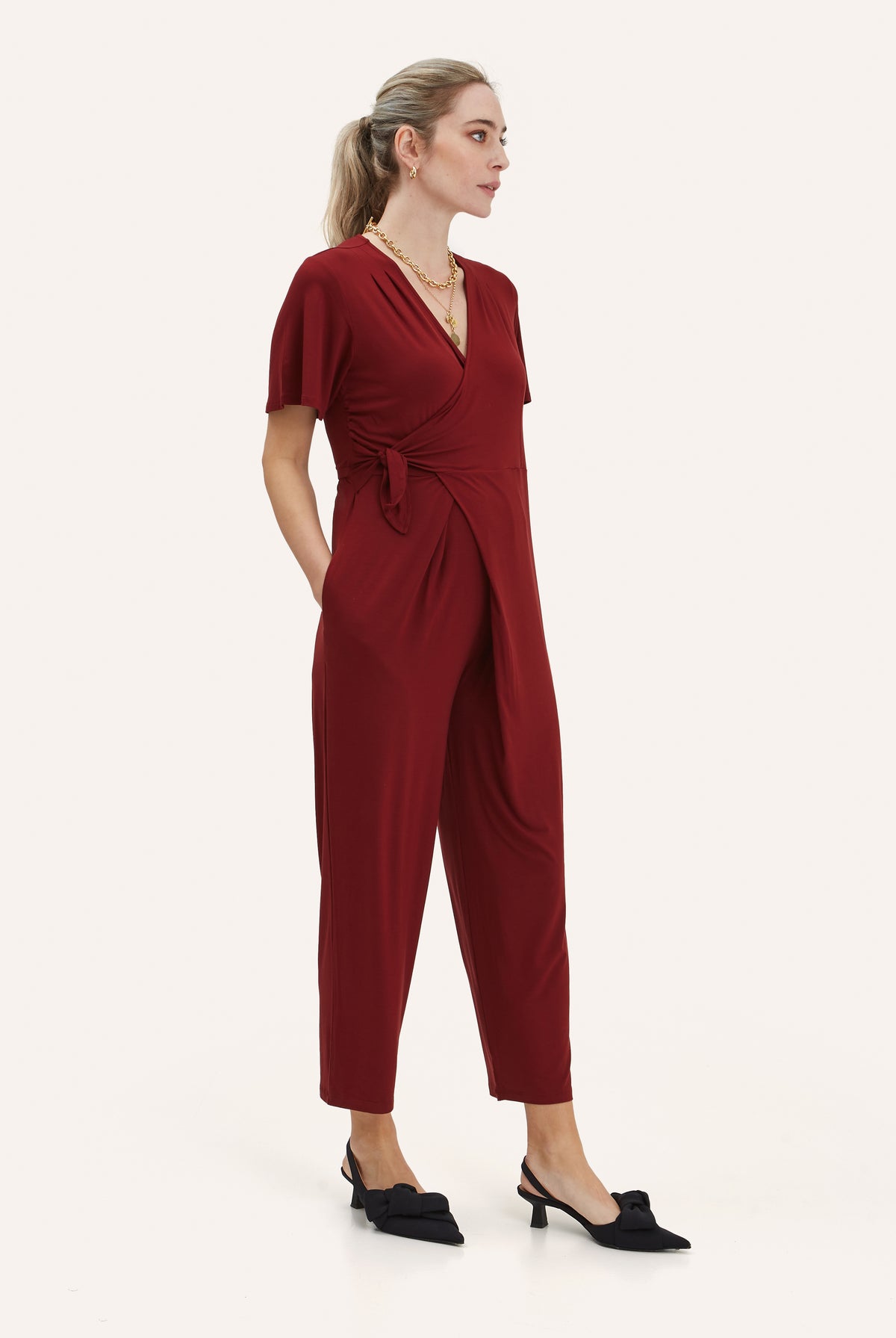 NOM Maternity Lucia Jumpsuit in Claret, three-quarter view showing wrap detail and pockets
