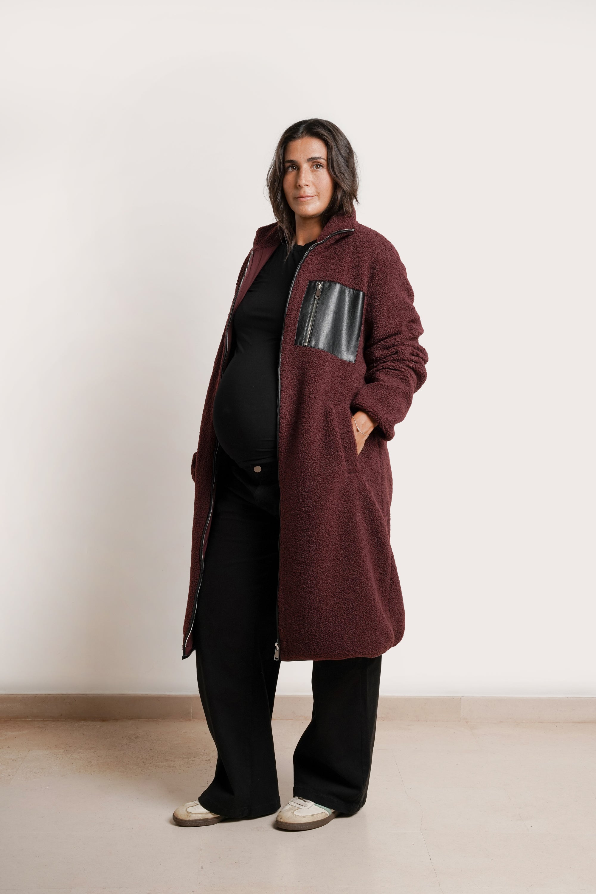 NOM Maternity Teddi Coat in Burgundy, three-quarter view open with bump