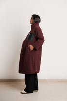 NOM Maternity Teddi Coat in Burgundy, side view showing pockets with bump
