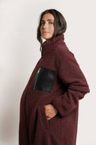 NOM Maternity Teddi Coat in Burgundy, close-up side view of pockets + sleeve cuffs